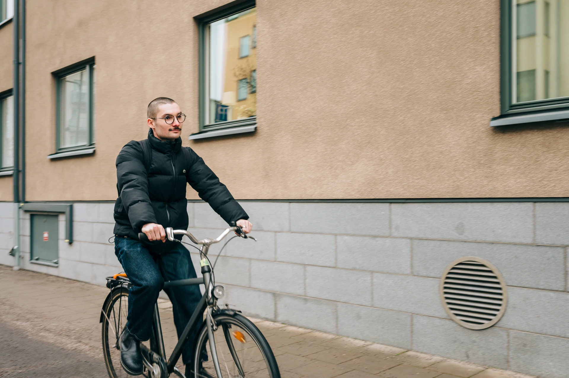 A man riding a bike down a street.