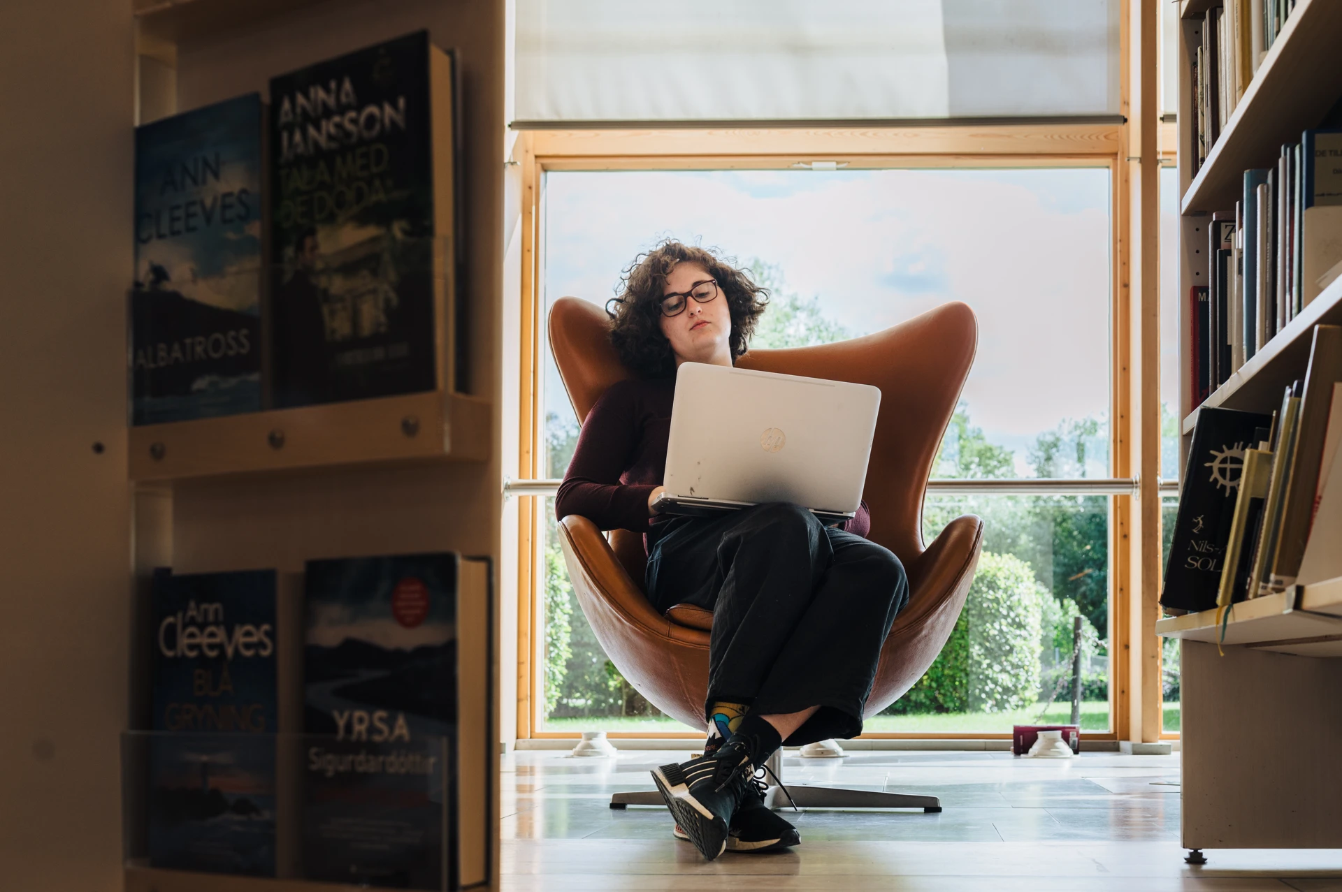 A woman sitting in a chair with a laptop.