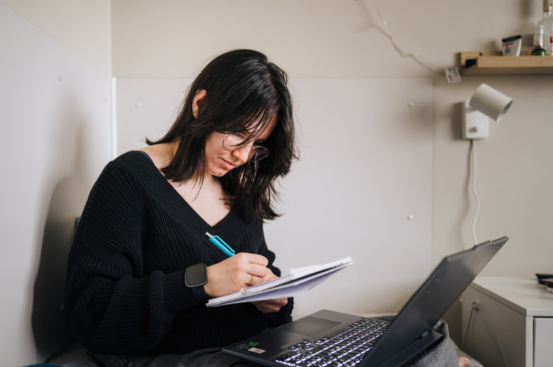 En kvinna sitter framf&ouml;r en b&auml;rbar dator.