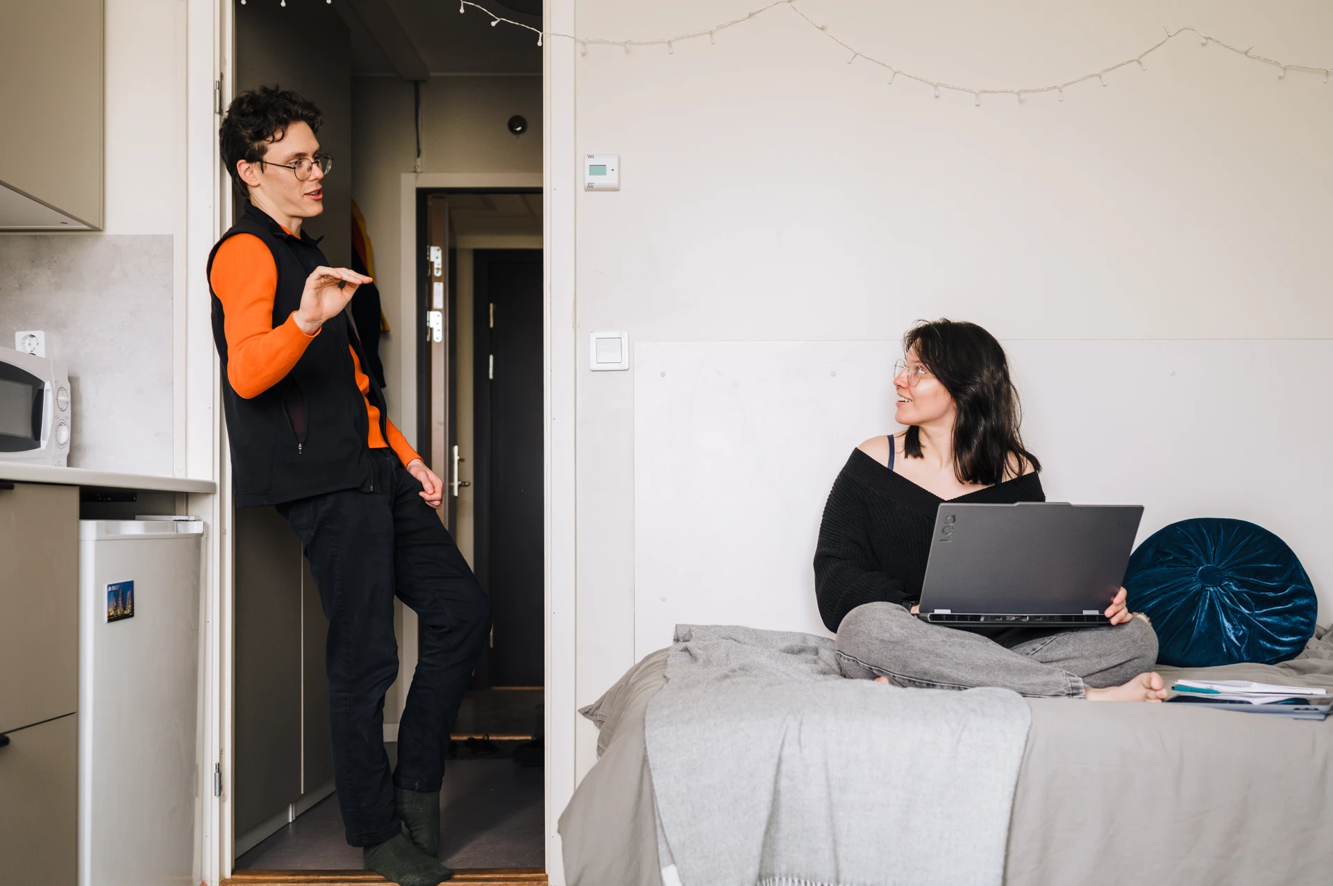 A woman sitting on a bed with a laptop.